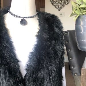Black faux fur vest .
